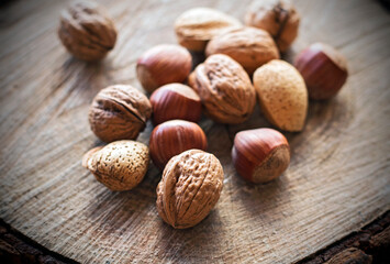 Varied nuts on wooden trunk