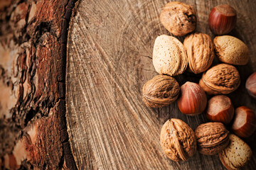 Varied nuts on wooden trunk