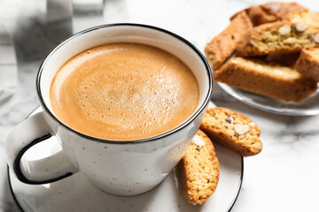 Tasty cantucci and cup of aromatic coffee on white table, closeup. Traditional Italian almond biscuits - obrazy, fototapety, plakaty