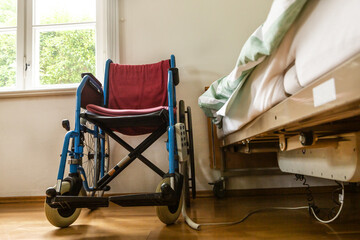 A wheelchair besides a nursing bed