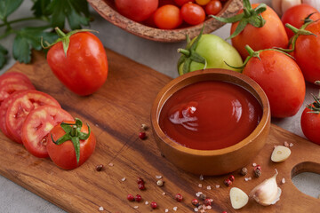 tomato sauce with garlic and  vibrant green leaves of the italian parsley plant. tomato ketchup sauce in a bowl with spices, herbs and cherry tomatoes. top view.