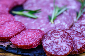 Sliced dry smoked salami sausage on a slate board