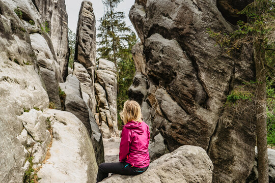 Ostas Nature Reserve and table mountain,Broumov region,Czech republic.Sitting girl enjoying view of rocks,caves,bizarre sandstone formations.Small natural town with labyrinth of rocks.Protected area