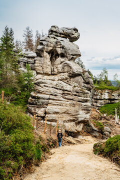 Ostas Nature Reserve and table mountain,Broumov region,Czech republic.Female backpacker in romantic rocky canynon enjoying view of bizarre sandstone formations and freedom of hiking.Labyrinth of rocks