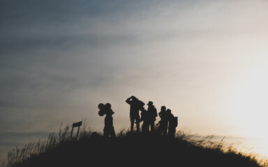 Silhouette photo a group of hikers on the top of the mountain beautiful evening light