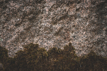 Moss on a rock surface. Relief and texture of stone with patterns and moss. Stone with moss.  Boulder covered with moss