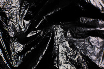 Crumpled Black Plastic Bag texture background. Glossy polyethylene overlay