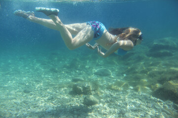 Fototapeta na wymiar Woman swimming underwater