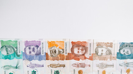 Colombian money of different denominations on white background