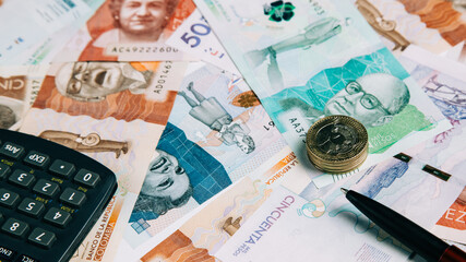 colombian money of different denominations with coins and calculator