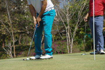 Golfers are putting golf in the evening golf course golf backglound. Golfer hitting golf ball....
