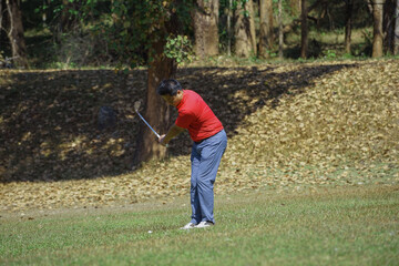Golfer are playing game golf and hitting go on green grass mountain background. Asia male player game shot in summer. Sport holiday lifestyle concept.