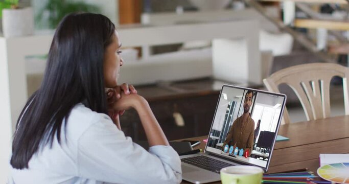 African american woman having a video call with male colleague on laptop at home