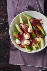 Melon with prosciutto, mozzarella balls and mint.
