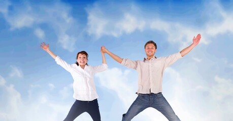 Composition of caucasian couple jumping and raising hands over blue sky with clouds