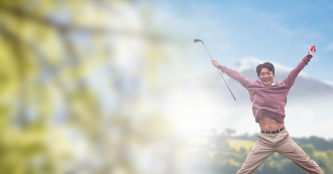 Composition of fit male golf player jumping and raising hands over blue sky with clouds