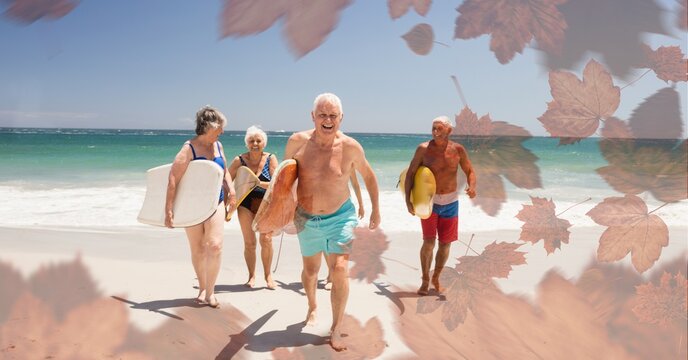 Composition of senior group with surfboards on beach and autumn foliage