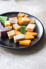 cheese different assortment variation aged cheeses basil, lavender, fenugreek, chili, baked milk, turmeric, carrot on the table healthy food meal snack copy space food background rustic top view