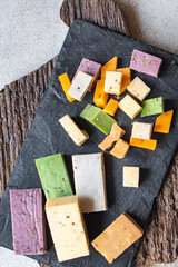 cheese different assortment variation aged cheeses basil, lavender, fenugreek, chili, baked milk, turmeric, carrot on the table healthy food meal snack copy space food background rustic top view