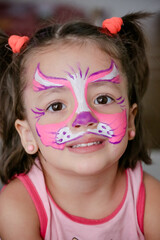 A criança olha com encanto, exibindo uma pintura artística vibrante no rosto que destaca sua expressão única e cheia de imaginação.