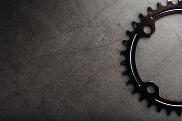 A black bicycle driving star with contrasting repeating cogs on a dark background