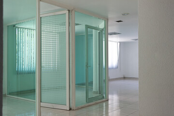 interior of an empty modern office with white concrete and glass doors. Bright empty space