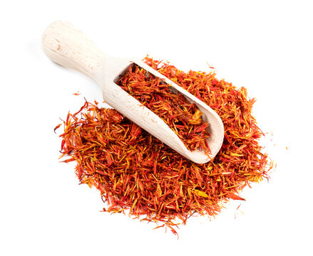 scoop on pile of dried safflower petals on white