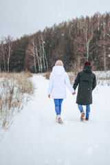 Fototapeta na wymiar boy and girl walking in winter park