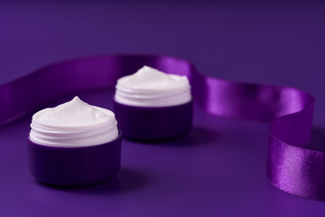night moisturizer and silk ribbon on a purple background.