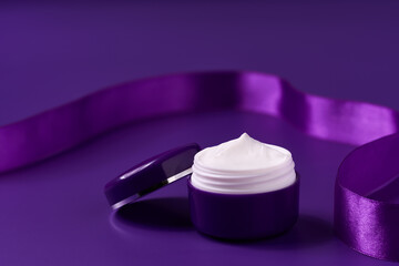 night moisturizer and silk ribbon on a purple background.