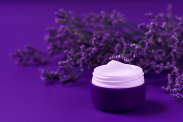 Obraz na płótnie Canvas Natural face or body night cream in a purple jar on a table, copy space for text.