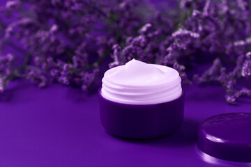 Obraz na płótnie Canvas Natural face or body night cream in a purple jar on a table, copy space for text.