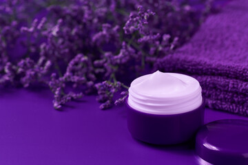 Obraz na płótnie Canvas jar of night face skin care cream for moisturizing and relaxing facial skin, on a purple table.