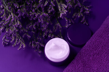 Obraz na płótnie Canvas jar of night face skin care cream for moisturizing and relaxing facial skin, on a purple table, top view.