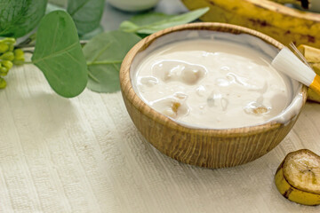 Homemade banana cosmetics. Cosmetic face mask with banana, oatmeal, honey, yolk. Natural skin care, wellness cosmetics,close-up. Diy banana mask,zero waste concept