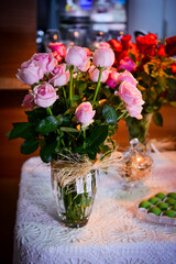  table decoration with bouquets of pink and red roses in vase, table decorated with roses