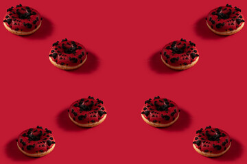 Fancy Donuts with cred glazed and chocolate topping on red backgroud .Pattern image