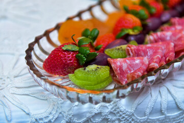 Italian hamburger-type salami fruits and apricot in a clear glass bowl, cold dish, cold platter,accompaniment to wine, snack to wine