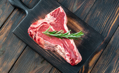 Raw T-bone steak with fresh rosemary