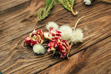 Herbarium. Dry herbs and flowers on a background from wooden boards. Rose, dandelions, juniper.