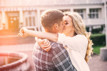 Beautiful bride and groom embracing and kissing on their wedding day outdoors