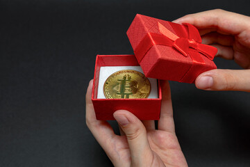 Bitcoin coin in gift box for ring or cryptocurrency jewelry concept, best gift. christmas and new year gift. Hands open gift box with bitcoin coin, banner.