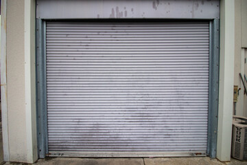 Large metal steel door behind shopping center on cloudy day in winter, super wide angle
