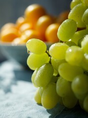 Bunch of fresh green grapes with a drop of water on a blue background. Yellow berries in the background, sunlight. Copy space. Space for text.