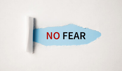 NO FEAR appearing behind torn paper. Motivation concept