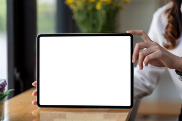 Workspace tablet blank white screen in woman hand holding at office. Mock up.