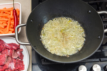 Cooking pilaf in a cauldron, a recipe for real pilaf.Fry onions in a cauldron for cooking pilaf,...