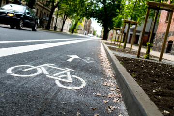 Obraz premium Freshly build bicycle lane in the city,Bike path. Sign white paint on the pavement. Summer. bicycle traffic sign painted on the asphalt.