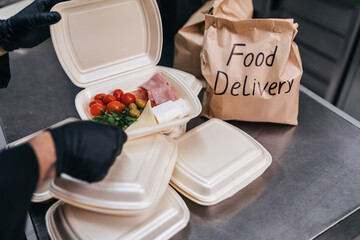 Food in disposable dishes ready for delivery. The chef prepares food in the restaurant and packs it in disposable lunch boxes.