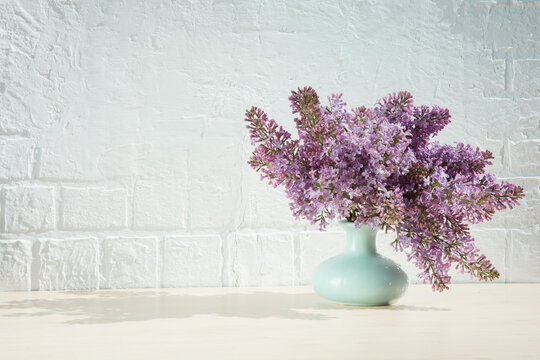 bouquet of purple lilacs in a turquoise vase